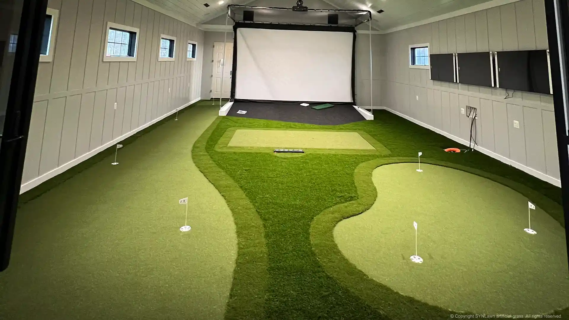 Dream indoor golf practice facility with custom putting green and golf simulator installed by SYNLawn image of an indoor golf simulator with custom putting green by SYNLawn Golf